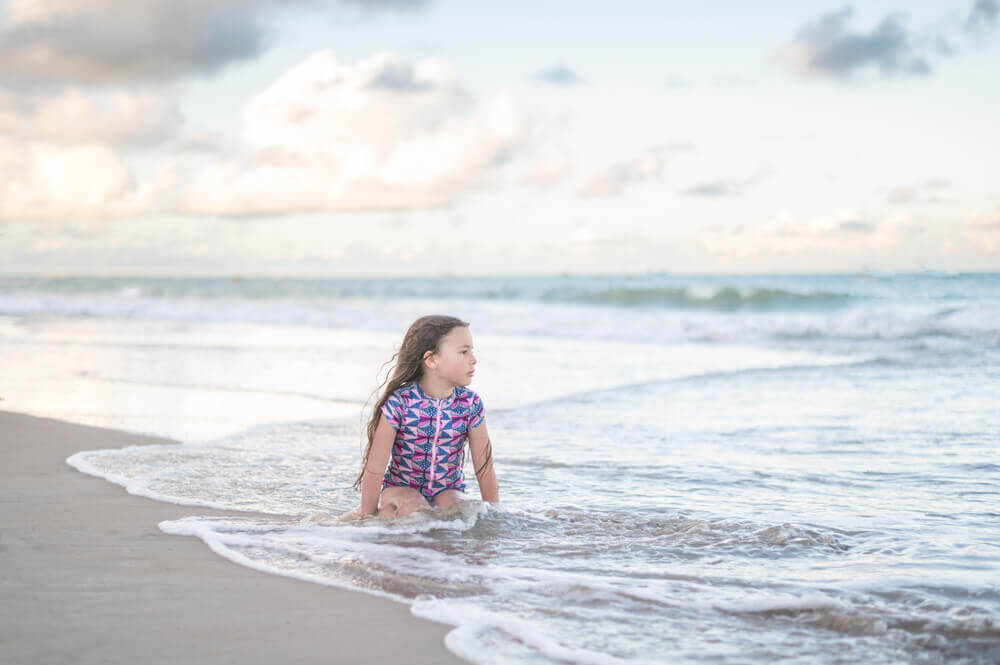 little girl watching the waves