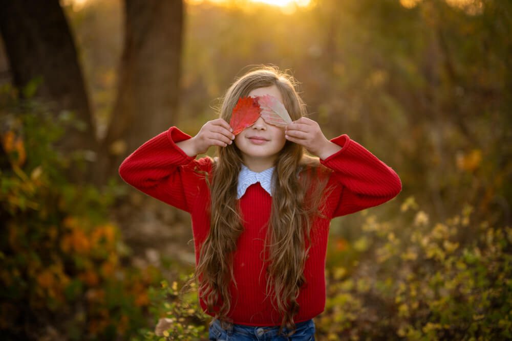girl playing with leaves in denver