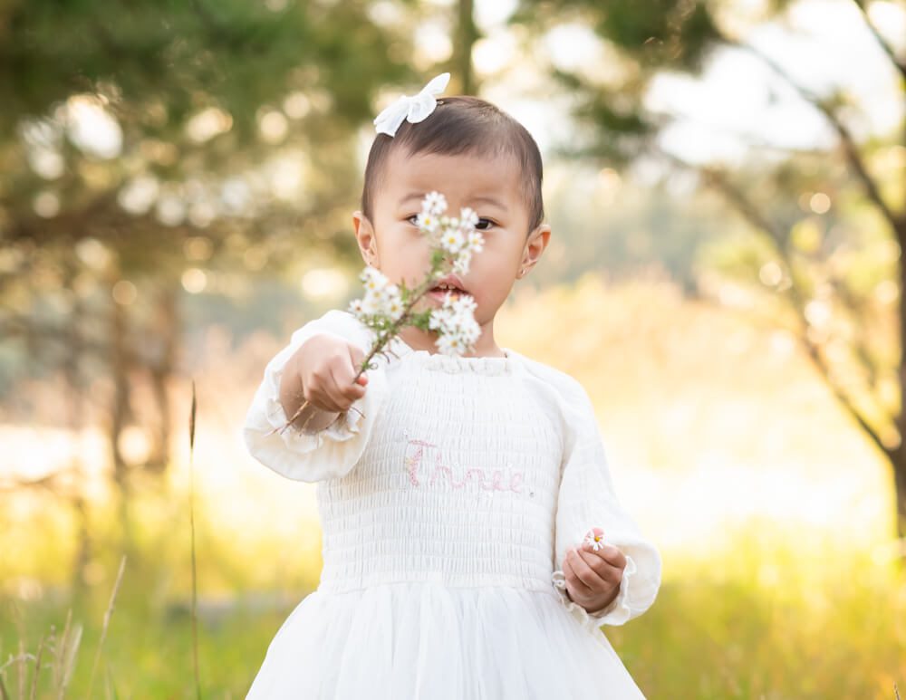 Little girl playing with wildflowers