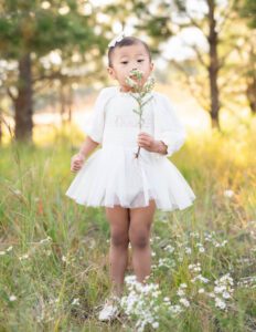 little girl smelling wildflowers