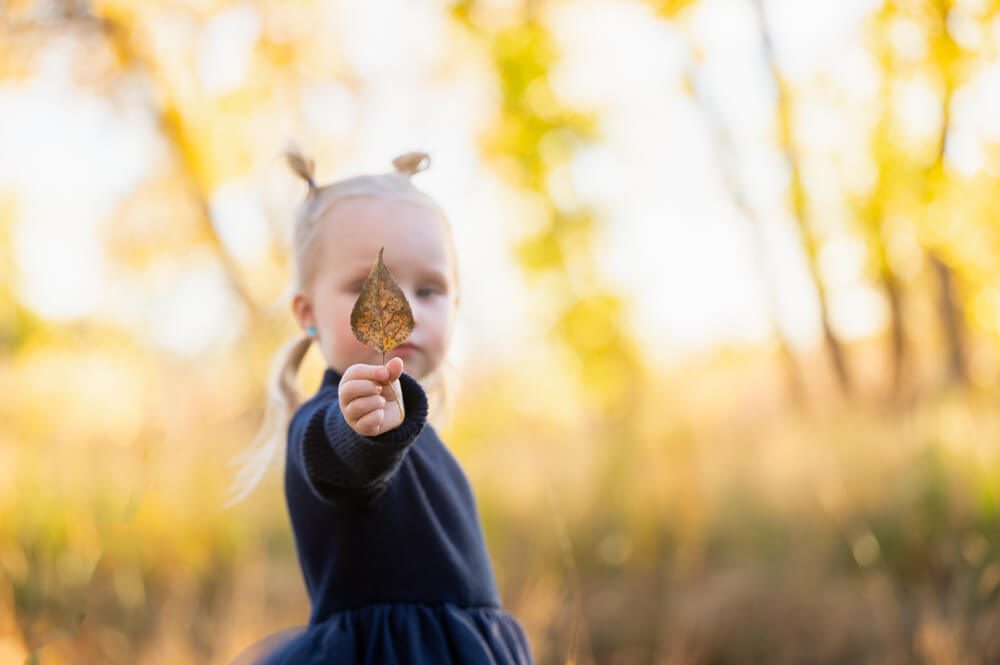 little kid playing with a leaf